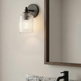 Lathan Wall Sconce 9", Aged Iron ribbed glass Wall Sconce in a Modern Farmhouse Bathroom with a wood framed mirror.