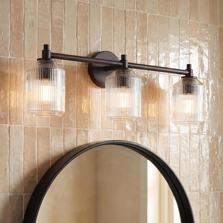 Lathan 3 Light Vanity 26", Aged Iron linear vanity in a Modern Farmhouse Bathroom with a round mirror and Zellige tile.