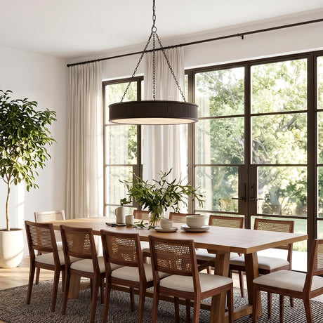 A transitional dining room featuring a Bishop Ring Chandelier 36 inch in aged iron over a light wood table with cane chairs on a textured rug.