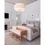 A transitional bedroom with the Daria Large Pendant 26, Gilded Brass and White suspended over a rattan bench and tufted bed beside a stone fireplace.