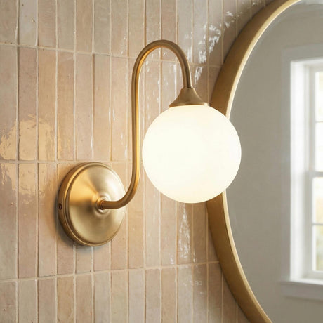 Aurelia Wall Sconce 10", Brushed Brass globe Wall Sconce in a Contemporary Bathroom with pink subway tile and round mirror.
