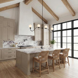 A farmhouse kitchen features the Leora 4 Light Linear Pendant 48-inch in Matte Black with white glass globes over a marble island under a vaulted beamed ceiling.