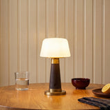 A traditional dining room featuring the Galina Rechargeable Table Lamp 11", Espresso Vegan Leather and Vintage Brass on a wooden table against a cream beadboard wall.