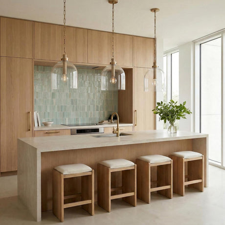 Aged Brass globe glass pendant in a Modern Kitchen with a waterfall island and sage green tile.