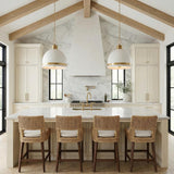 A farmhouse kitchen features two Patrice Large Pendant 20", Matte White and Aged Brass fixtures over a marble island under a vaulted beamed ceiling with woven stools.