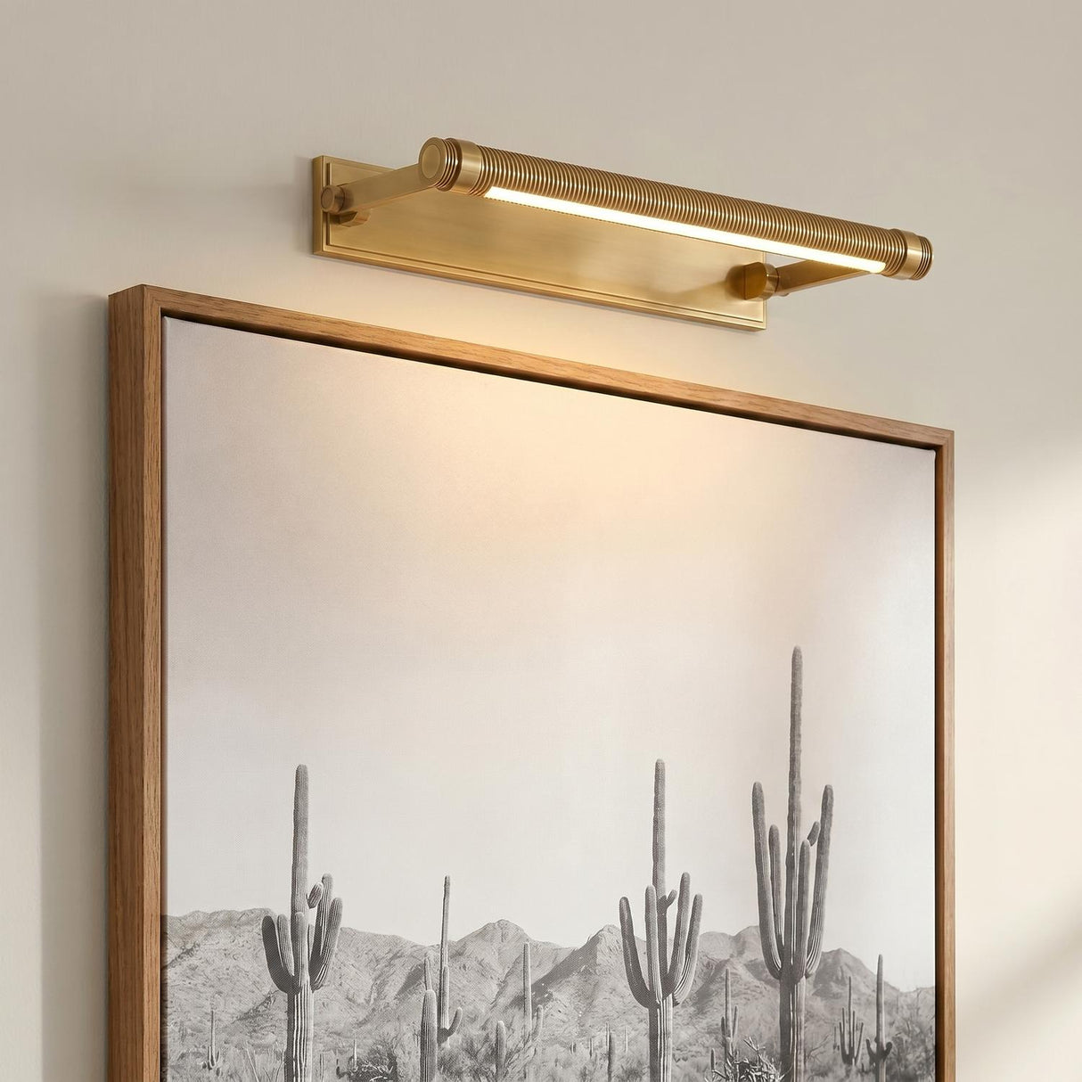 A transitional living room with the Heath LED Picture Light 18", Aged Brass in an aged brass finish mounted above a framed desert landscape painting.