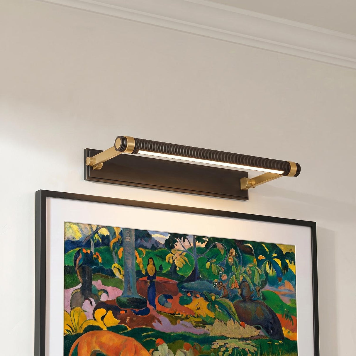 A transitional hallway featuring a Heath LED Picture Light 18-inch in distressed bronze and aged brass mounted over a framed colorful painting on a white wall.