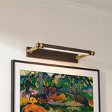 A transitional hallway featuring a Heath LED Picture Light 18-inch in distressed bronze and aged brass mounted over a framed colorful painting on a white wall.