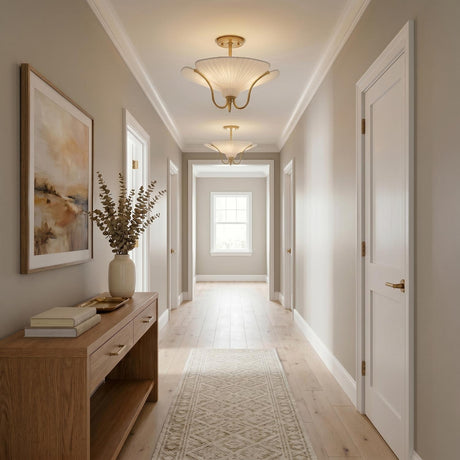 A transitional foyer with two Marcelle semi-flush mounts in aged brass and linen along the ceiling above a wood console and light oak flooring.