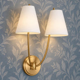 A transitional foyer featuring the Cordelia Double Wall Sconce 18", Modern Brass with white fabric shades mounted on blue botanical patterned wallpaper.