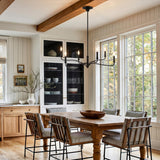 A modern farmhouse dining room with the Harwick 6 Light Chandelier 32" in aged iron over a wood table featuring beamed ceilings and shiplap walls.