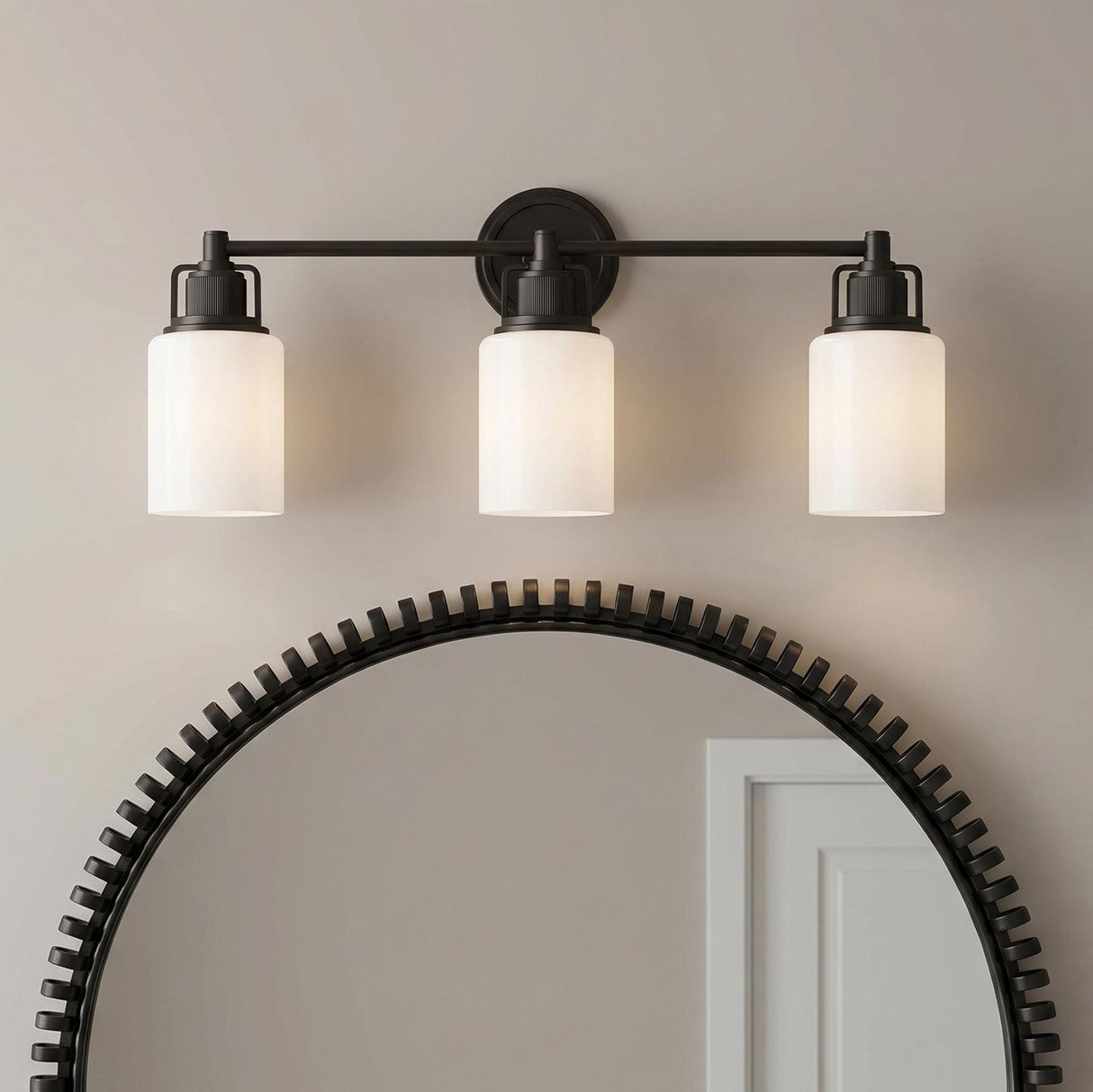 A transitional bathroom features a Claxton 3 Light Vanity 24", Aged Iron with frosted glass shades mounted over a large textured circular mirror.
