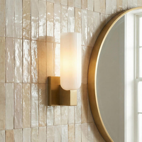 Vesper Wall Sconce 12", Modern Brass geometric Wall Sconce in a Contemporary Bathroom with a textured tile wall and round gold mirror.