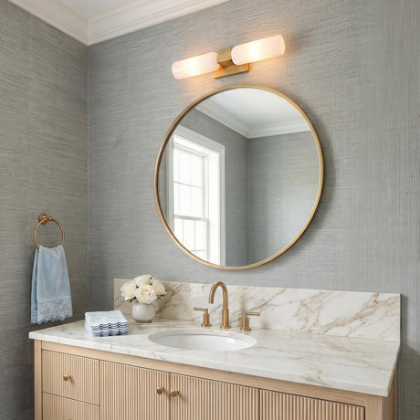 A transitional bathroom with a modern brass and frosted glass vanity light mounted over a circular mirror above a white marble countertop and fluted wood vanity.