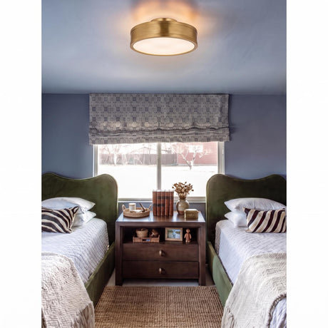 A transitional bedroom with the Merton Round LED Semi-Flush 12", Gilded Brass fixture centered above two green velvet twin beds and a dark wood nightstand.