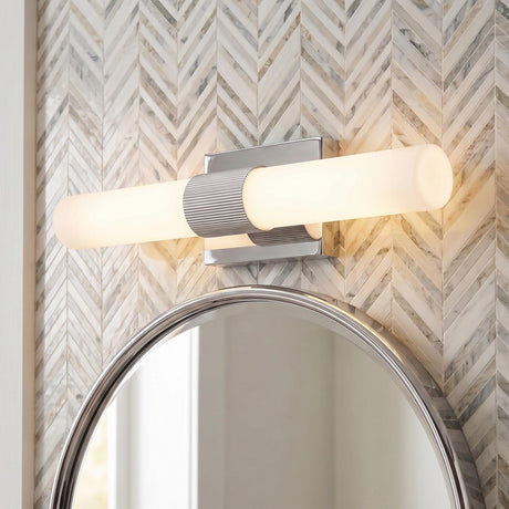 A contemporary bathroom with the Ramsey LED Vanity Light 18", Chrome featuring a polished chrome finish and frosted glass above a round mirror and chevron marble tile.
