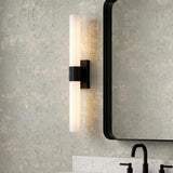 A contemporary bathroom with the Ramsey LED Vanity Light 24", Matte Black featuring frosted glass and a ribbed center, mounted beside a black-framed mirror over a white marble countertop.