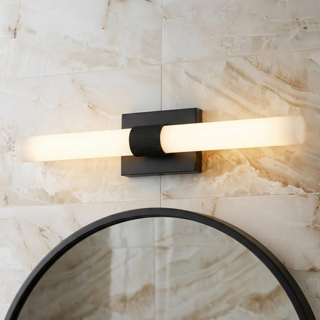A modern bathroom with the Ramsey LED Vanity Light 30", Matte Black in a matte black finish with ribbed glass over a round mirror and marble wall.