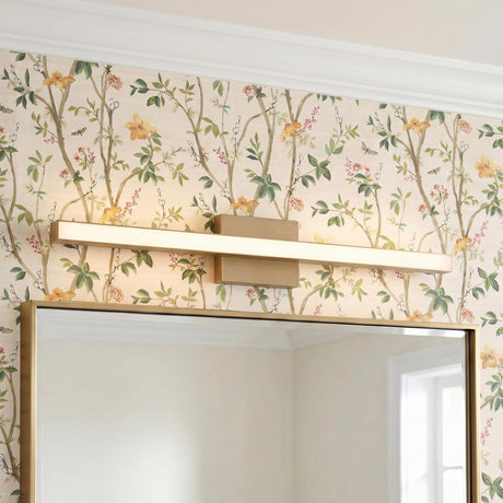 A transitional bathroom with the Garrison LED Vanity Light 30", Satin Brass mounted above a matching gold framed mirror against floral wallpaper and white crown molding.