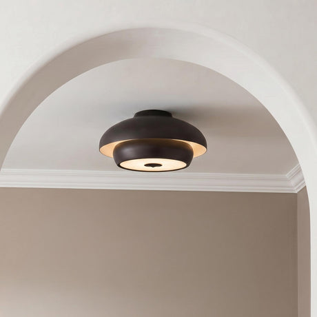 A modern foyer features the Garnett Semi-Flush in aged iron mounted to a white ceiling above a large interior archway and neutral taupe walls.