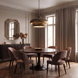 A transitional dining room with the Garnett Extra Large Pendant in vintage gilded brass centered over a dark wood round table and herringbone wood floors.