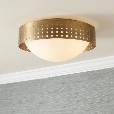 A contemporary foyer with the Egan Medium Flush Mount 14", Vintage Brass featuring a perforated brass band and frosted glass bowl against textured blue grasscloth wallpaper.