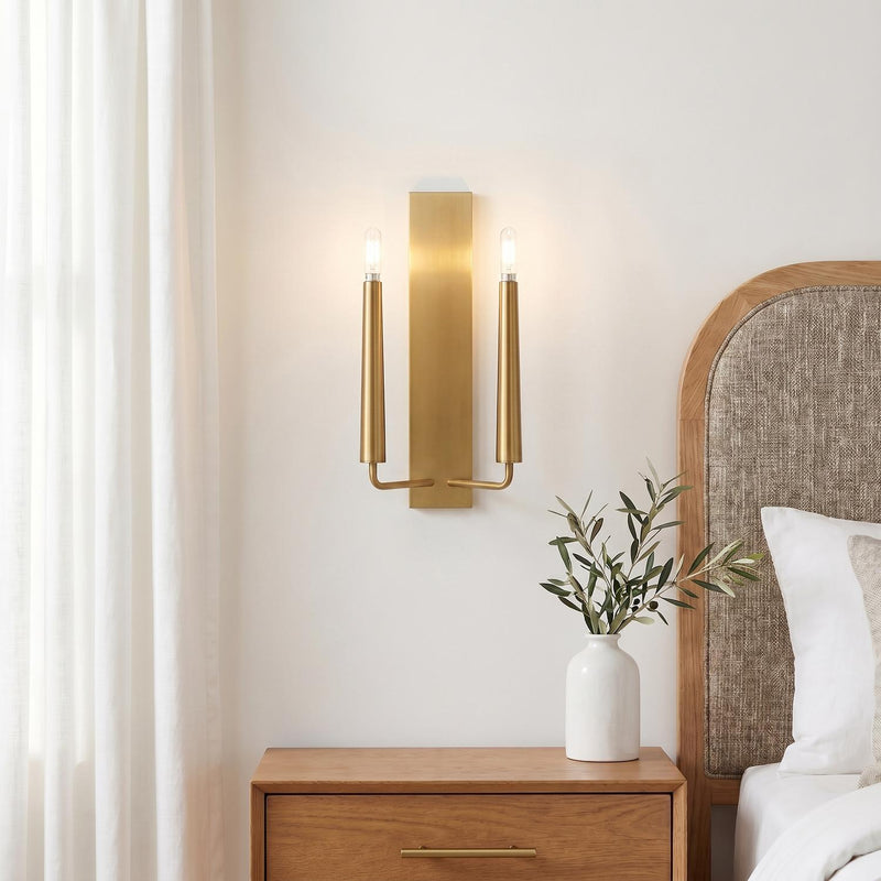 A modern bedroom featuring the Solana Double Wall Sconce 18", Modern Brass on a white wall above a wooden nightstand and a linen-upholstered oak headboard.