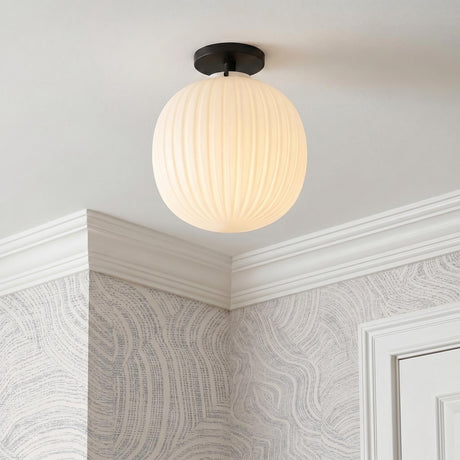 A contemporary foyer with a matte black and ribbed milk glass semi-flush mount along the ceiling with gray swirled wallpaper and white crown molding.