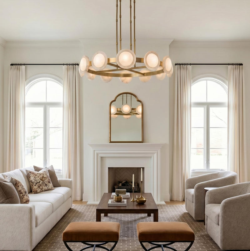 A transitional living room featuring the Osmund LED Chandelier 50 inch, Vintage Brass and Alabaster, centered above a walnut coffee table and white mantel fireplace.