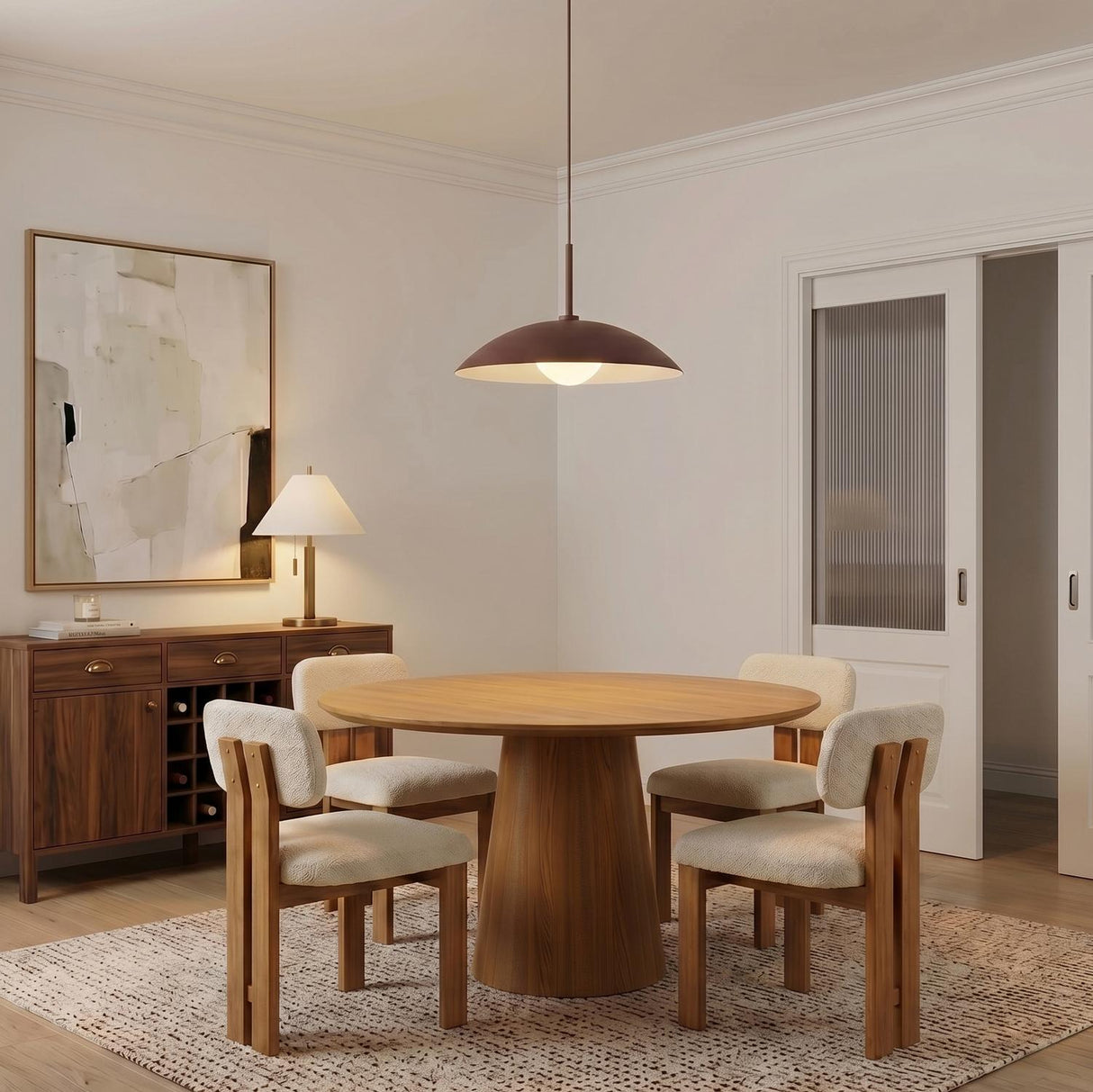 A mid-century dining room features the Lenora Metal Pendant 19", Maroon over a round walnut pedestal table, surrounded by boucle chairs and a dark wood sideboard.