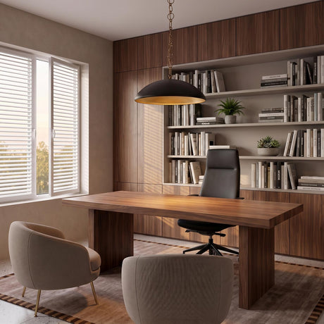 A mid-century office with the Charlie Pendant 28", Matte Black and Brushed Brass hanging over a walnut executive desk and built-in wood shelving filled with books.