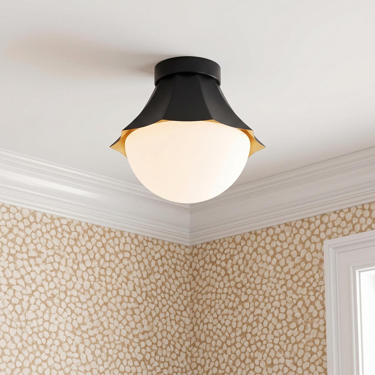 A transitional foyer featuring a matte black and opal glass semi-flush mount along a standard white ceiling beside tan patterned wallpaper and white crown molding.
