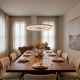 A contemporary dining room with the Amir Large LED Chandelier 30", Aged Iron and ribbed glass over a walnut table and upholstered beige chairs.