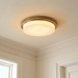 A traditional foyer with the Martine LED Flush Mount 16 inch in aged brass and opal glass installed on a ceiling with white crown molding.