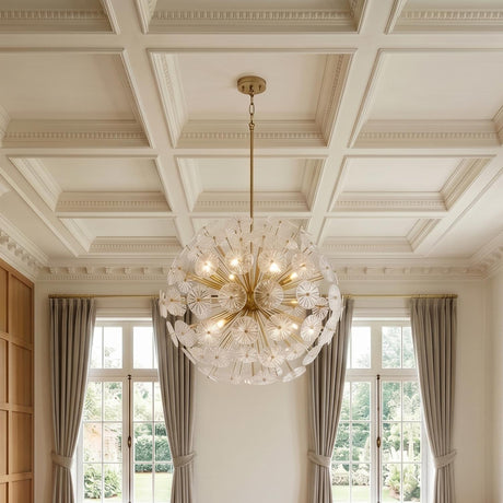 A transitional living room with a matte brass and clear glass pendant hanging from a white coffered ceiling between tall windows with floor-length beige drapes.