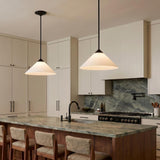 A modern kitchen with two matte black and opal glass cone pendants suspended over a green marble island and beige cabinetry with integrated hardware.
