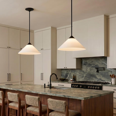 A modern kitchen with two matte black and opal glass cone pendants suspended over a green marble island and beige cabinetry with integrated hardware.