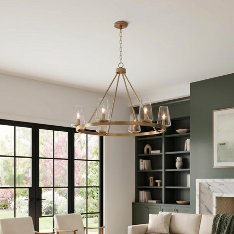 A transitional living room with an aged brass chandelier featuring tapered glass shades centered in the space near dark green built-in shelving and a marble fireplace.