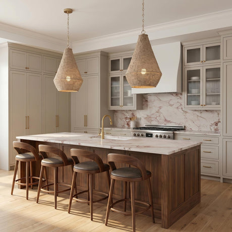 A transitional kitchen with two natural wooden bead cone pendants in a matte brass finish hanging over a walnut wood island with pink marble countertops and backsplash.