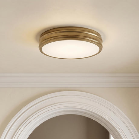 A transitional foyer with the Vanessa LED Flush Mount 16", Aged Brass centered on the ceiling above a white architectural arched doorway and crown molding.