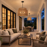 A coastal covered porch with two Luma 4 Light Outdoor Pendants in sienna and matte black hanging from a white ceiling over lounge seating at dusk.
