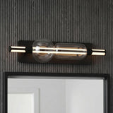 A modern bathroom featuring a Latimer LED Vanity Light 26" in matte black and clear glass mounted above a mirror on a dark grey slat wall.