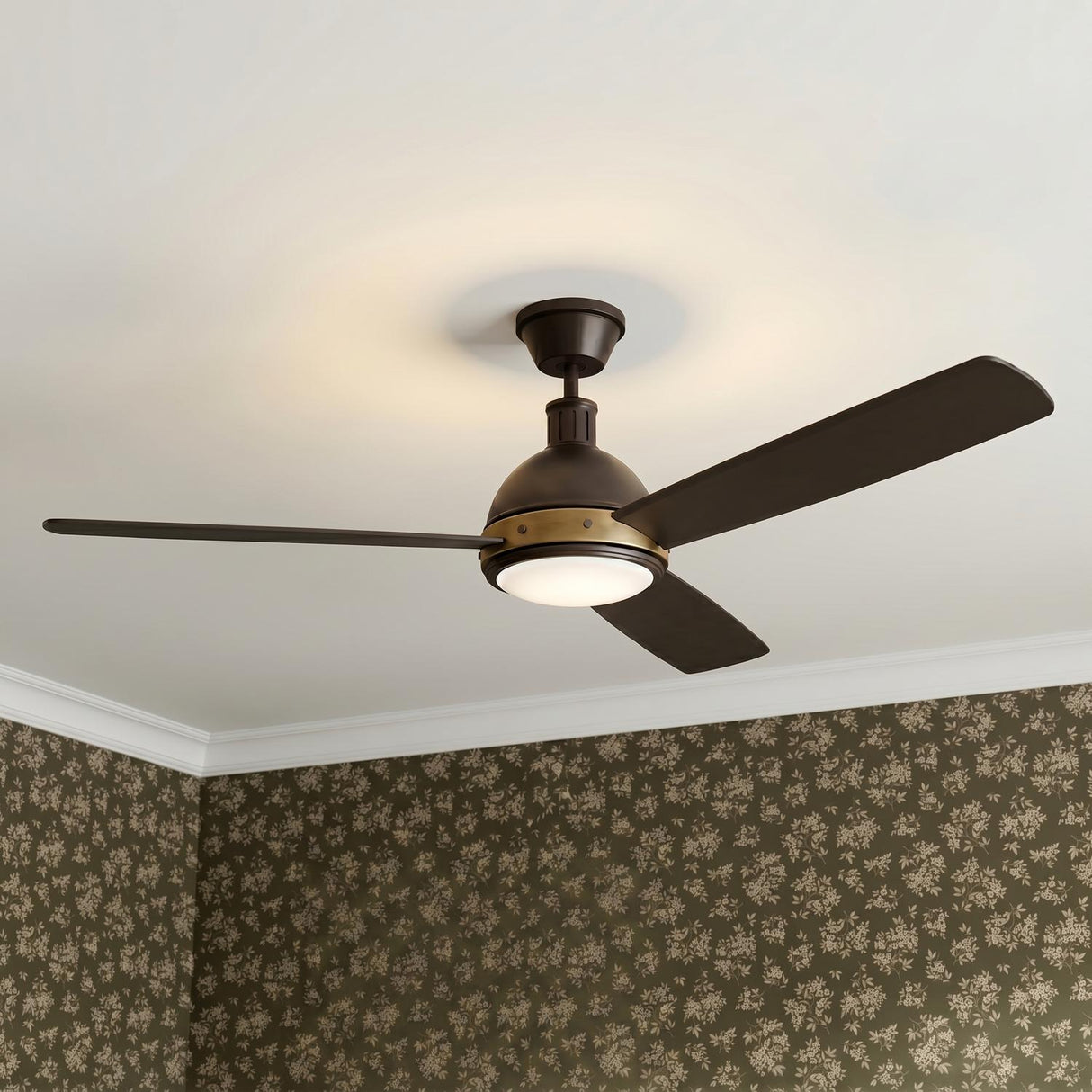 A transitional bedroom featuring the Brant LED Ceiling Fan 60 inch in urban bronze and antique brass finishes centered on a white ceiling with floral patterned wallpaper.