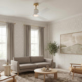 A contemporary living room with the Condor LED Ceiling Fan 52 in Matte White with Modern Brass along the ceiling center over a grey sofa.