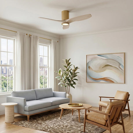 A modern living room with the Avocet LED Ceiling Fan 44", Modern Brass and Whitewash Oak mounted on the ceiling above a grey sofa and tan armchairs.