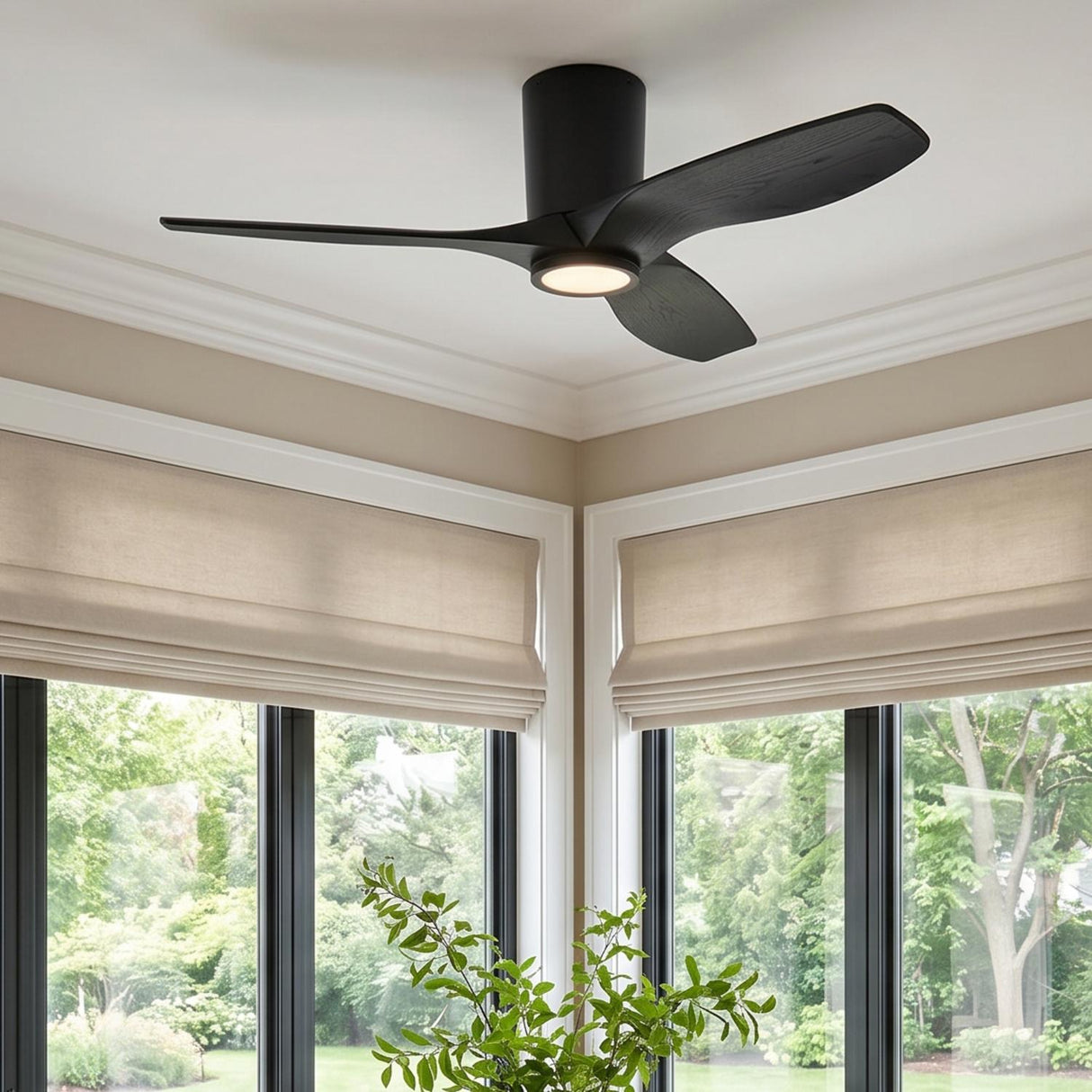 A modern living room featuring the Avocet LED Ceiling Fan 44", Matte Black Oak installed in the ceiling center above large windows with beige Roman shades.