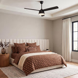 A contemporary bedroom with the Linnet LED Ceiling Fan 60 in matte black installed on a coffered ceiling above a white channel-tufted headboard and fluted nightstands.