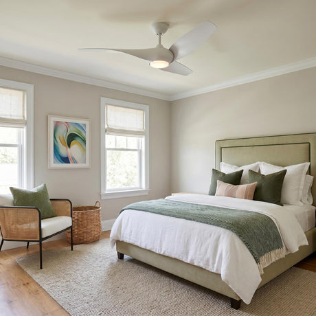 A contemporary bedroom with a matte white Krestel LED Ceiling Fan 52" mounted in the ceiling center above a sage green upholstered bed and woven rattan chair.