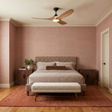 A mid-century bedroom featuring the Egret LED Ceiling Fan 52", Natural Oak and Matte Black at the ceiling center above a patterned headboard and mauve grasscloth walls.