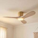 A transitional bedroom with the Eider LED Ceiling Fan 44", Whitewash Oak and Modern Brass, mounted to the ceiling center near cream curtains and a macrame hanging.